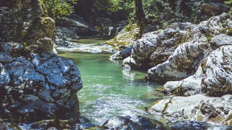 Serene Creek Flowing Through Rocky Landscape wallpaper