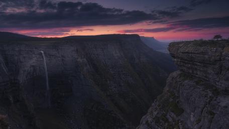 Majestic Sunrise Over a Serene Waterfall wallpaper