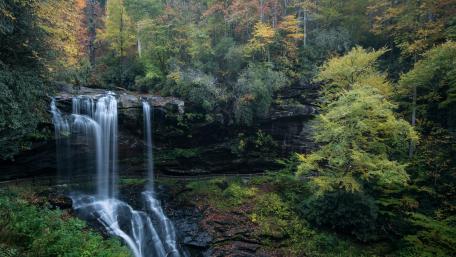 Majestic Autumn Waterfall in Tranquil Forest wallpaper