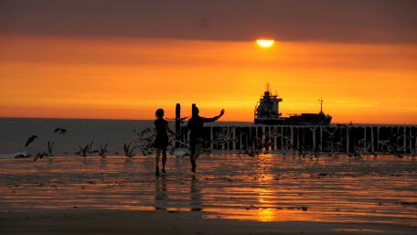Couple silhouette on the beach at sunset wallpaper