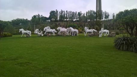 Majestic White Horse Statues in Lush Greenery wallpaper