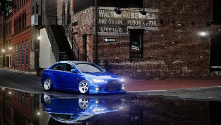 Sleek Blue Mitsubishi in Urban Reflection at Night wallpaper