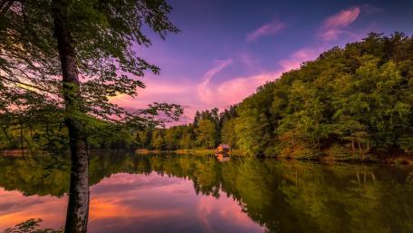 Serene Sunset Reflection Over Tranquil Lake wallpaper
