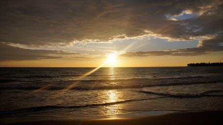 Golden Sunrise Over Tranquil Ocean Waves wallpaper