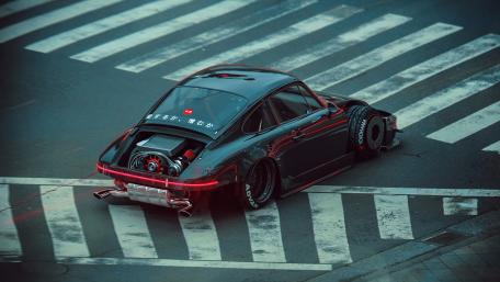 Sleek Black Porsche Racing through the Streets wallpaper