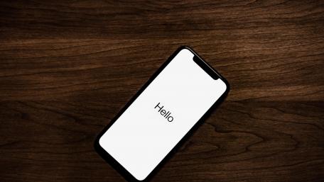 Modern Smartphone Greeting on Wooden Table wallpaper