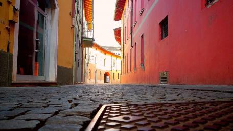 Charming Cobblestone Street in a Vibrant City Scene wallpaper
