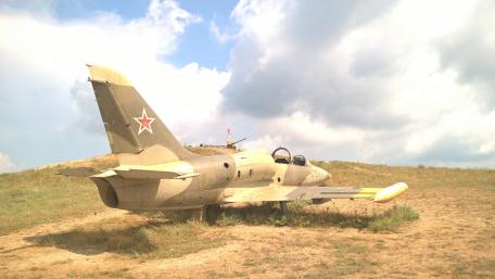 Vintage Military Aircraft on Display in Nature Scene wallpaper
