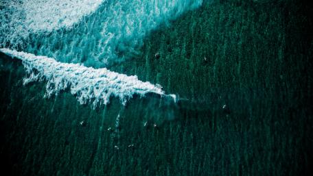 Aerial Surfing Adventure Over Ocean Waves wallpaper