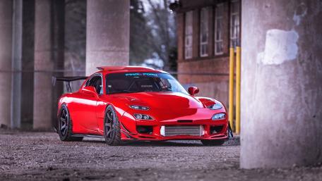 Sleek Red Sports Car Under Urban Overpass wallpaper