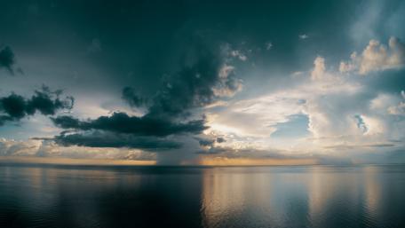Serene Horizon with Cumulus Clouds and Ocean Reflections wallpaper