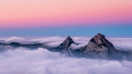 Dawn's Embrace Atop the Cloud Veiled Peaks wallpaper