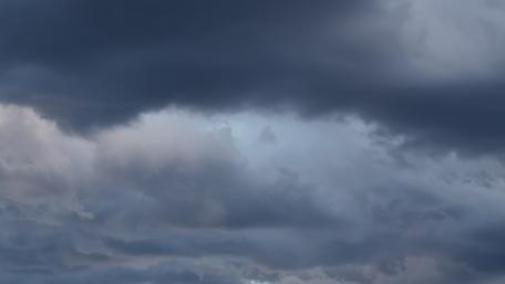 Dark Clouds Embrace the Sky Surrounding Light wallpaper