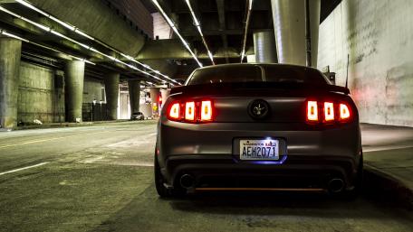 Sleek Black Car Under Urban Lights wallpaper