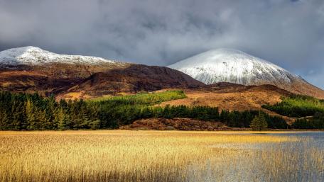 Highland Serenity Amid Snowcapped Peaks wallpaper