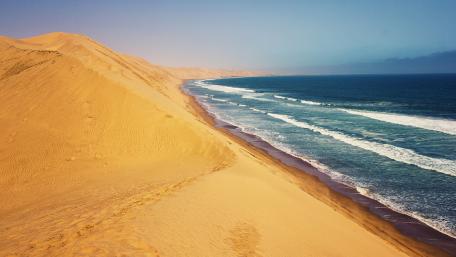 Golden Dunes Meeting the Ocean Waves wallpaper