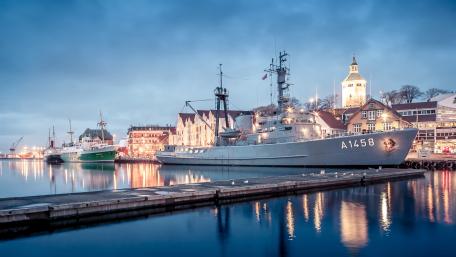 Sleek Navy Vessel Moored in Tranquil Harbor Scene wallpaper
