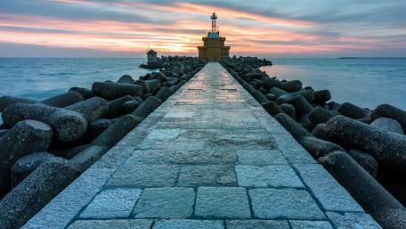 Serene Lighthouse at Dusk Over Sea Horizon wallpaper