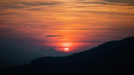 Stunning Orange Sunset Over Majestic Mountains wallpaper