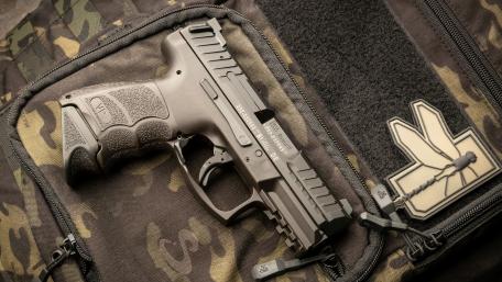 Tactical Handgun on Camo Background 4K wallpaper