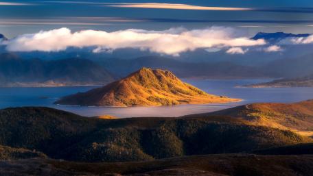 Serene Island Oasis Amidst Majestic Mountains wallpaper