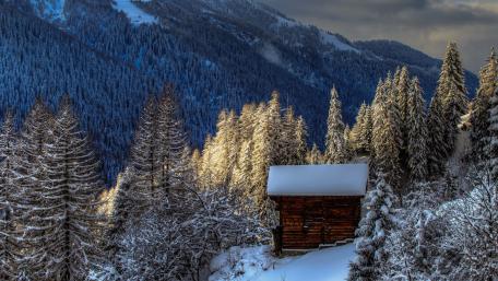 Snowy log cabin in Switzerland wallpaper