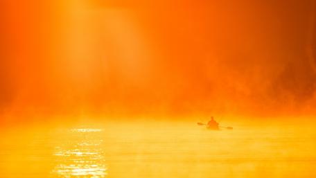 Vibrant Kayaking at Sunrise Over Calm Waters wallpaper