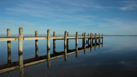 Jetty reflected in lake wallpaper