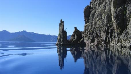 Serene Lake Reflection Amidst Majestic Cliffs wallpaper