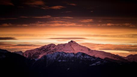 Orange sky over the snowy mountain wallpaper