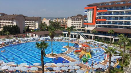 Vibrant City Resort with Sparkling Pool and Palm Trees wallpaper