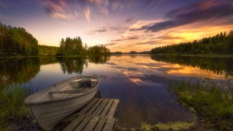 Serene Lakeside Sunset Reflection With Boat wallpaper