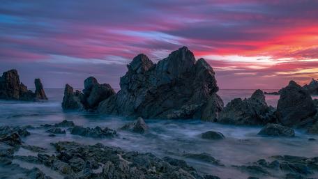 Majestic Coastal Sunset Over Rugged Rocks wallpaper