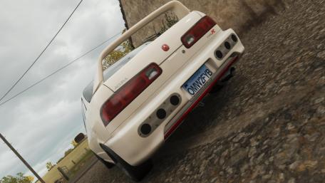 Sleek White Sports Car on Gravel Road wallpaper