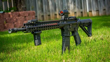 Assault Rifle in Grass Background wallpaper