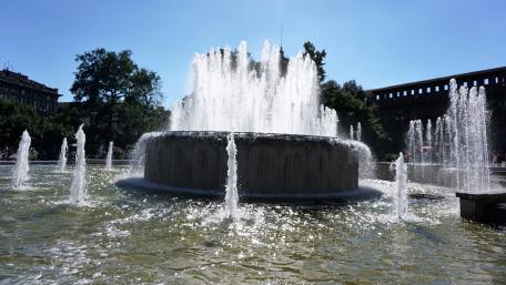 Majestic Fountain in Sunlit Cityscape wallpaper