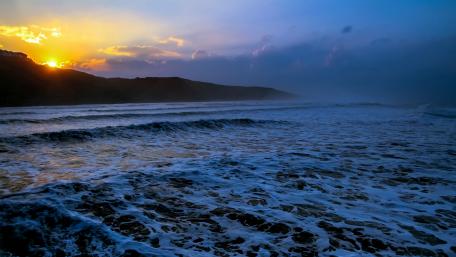 Foamy sea waves at sunset wallpaper