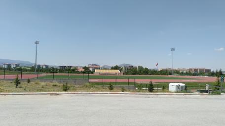 Urban Sports Field with Clear Blue Sky and Mountains Behind wallpaper