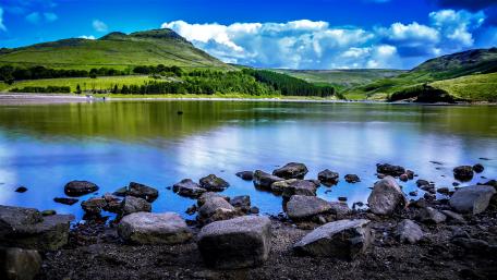 Serene Lakeside with Boulders and Hills wallpaper
