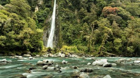 Majestic Waterfall Amidst Lush Greenery wallpaper