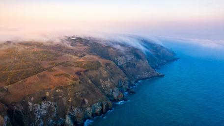 Mysterious Mist Over Serene Coastline View wallpaper