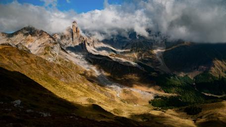 Majestic Mountain Peaks Under Cloudy Skies wallpaper