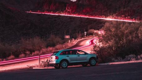 Sleek SUV on a Winding Road at Night wallpaper