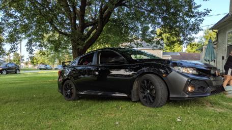 Sleek Black Car on Lush Green Grass wallpaper