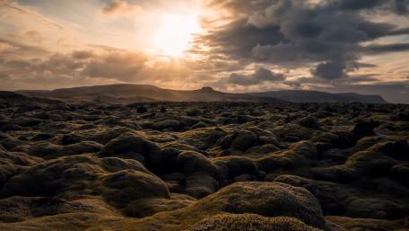 Mossy Landscape Under Dramatic Skies wallpaper