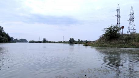 Serene River Landscape with Power Lines wallpaper