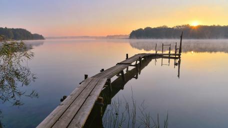 Serene Sunrise Over Calm Lake Waters wallpaper