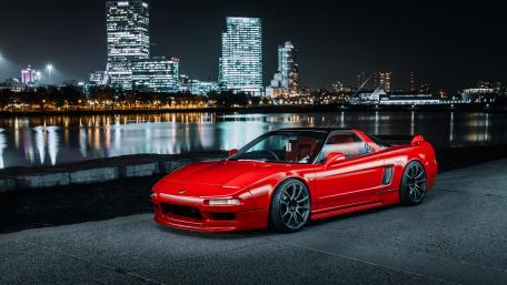 Sleek Red Sports Car by City Lights wallpaper