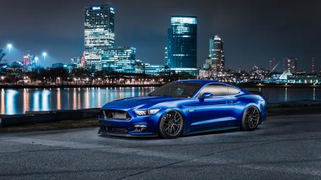 Blue Mustang at Nighttime Cityscape wallpaper