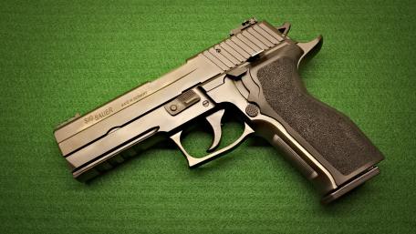 Powerful Handgun on Green Background wallpaper